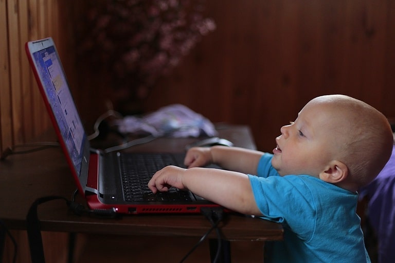 baby attempting to work on a computer