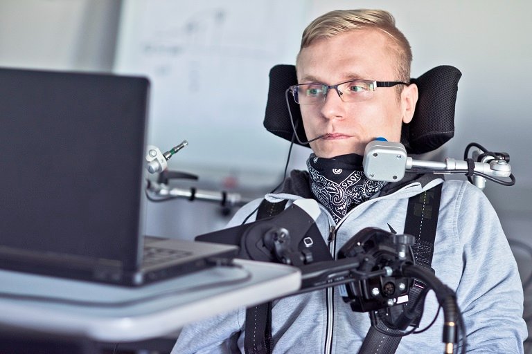 Disabled man using assistive technology to work on laptop