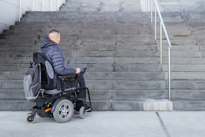 Disabled man with muscular dystrophy on an electric wheelchair who can't get up the stairs.