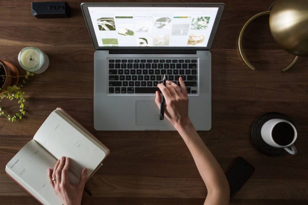 woman working on a laptop and taking notes